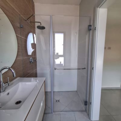 מקלחת עם דלת זכוכית וברז גשם