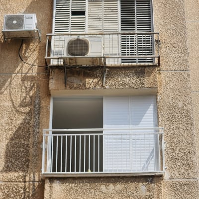 מסגרת חלון עם תריסים לבנים פתוחים