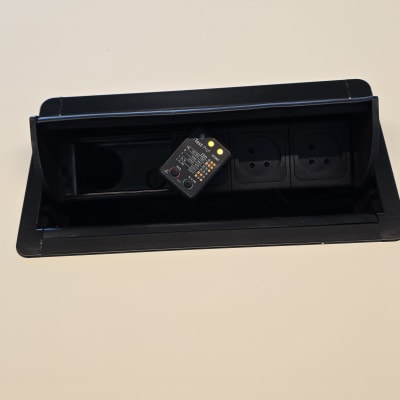 שקע חשמלי עם בודק מתח על שולחן