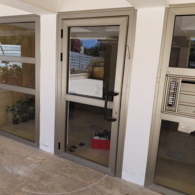 דלת אלומיניום עם ידית שחורה וחלון זכוכית