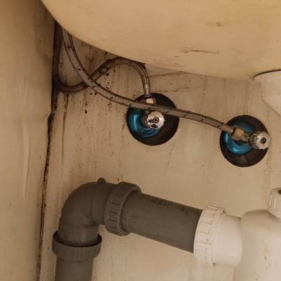 צינורות מתכת וברזים מתחת לכיור