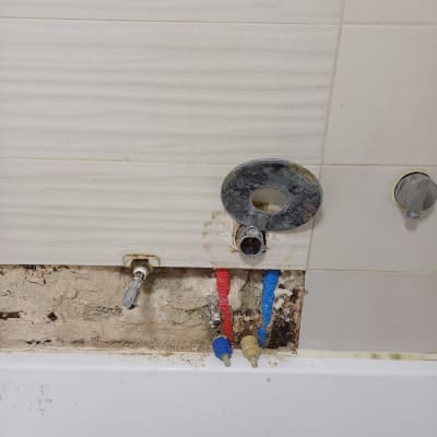 צינורות מים חשופים בקיר עם חיבורים