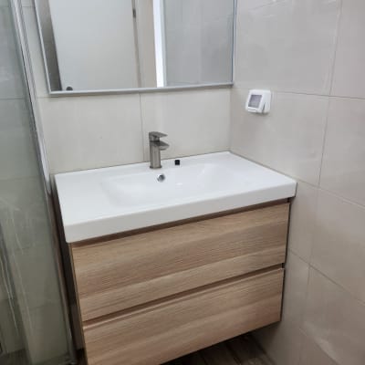 כיור עם ברז מודרני וארון עץ מתחתיו