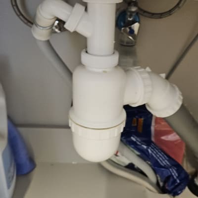 צנרת מתחת לכיור עם חיבורים לבנים