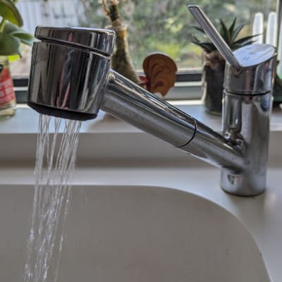 ברז מטבח עם מים זורמים לכיור לבן