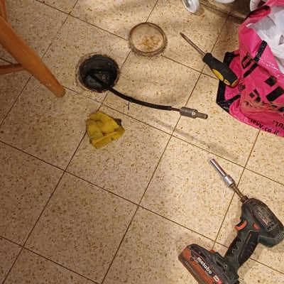 כלים ועבודת אינסטלציה על רצפה עם מקדחה ומברג