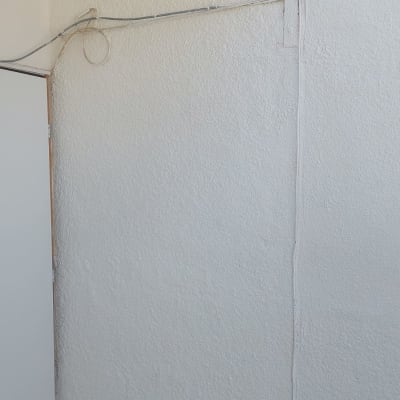קיר צבוע בלבן עם חוטי חשמל גלויים