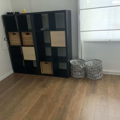 רצפת פרקט עץ חום בחדר עם מדפים וסלים