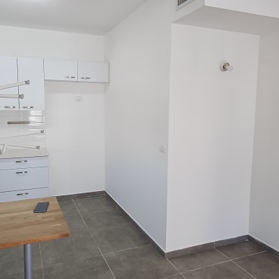 מטבח ריק עם קירות לבנים ורהיטים הפוכים