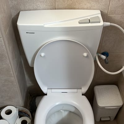 אסלה עם מיכל הדחה וצינור מים מחובר