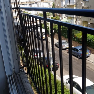 מעקה ברזל שחור במרפסת עם נוף לרחוב