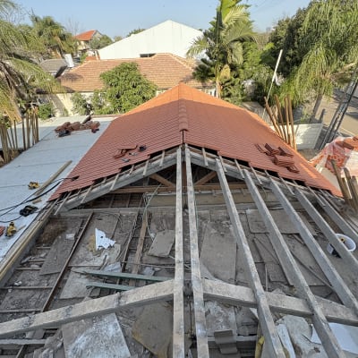 גג רעפים בתהליך בנייה עם כלים וחומרים