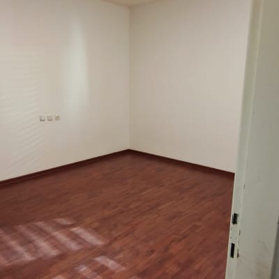 חדר ריק עם רצפת עץ ותאורה עליונה