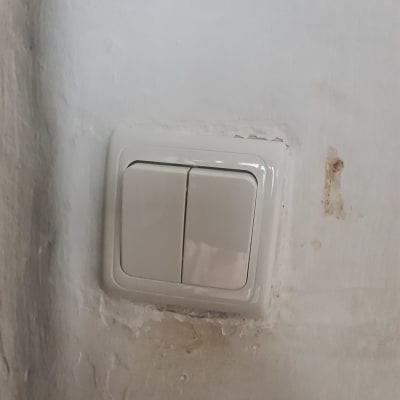 מתג חשמל כפול על קיר לבן