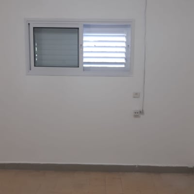 קיר עם מזגן וחלון, שקעי חשמל על הקיר