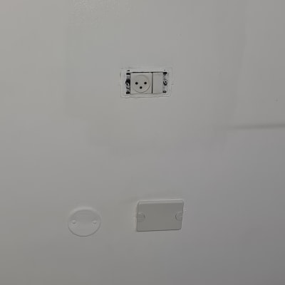 שקע חשמל בקיר לבן עם כיסוי פלסטיק
