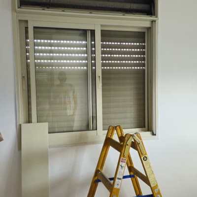חלון עם תריסים, סולם וכלי עבודה