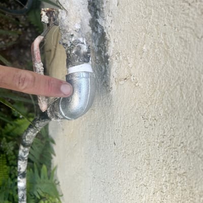 אצבע מצביעה על צינור מתכת עם חיבור זוויתי