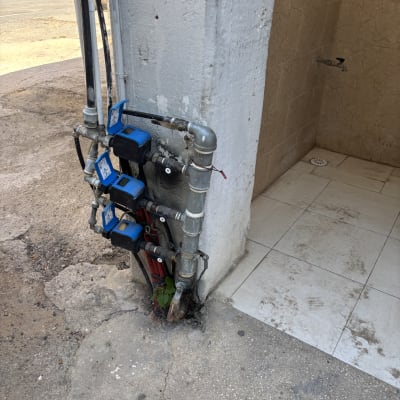 צנרת מים עם ברזים ליד קיר חיצוני