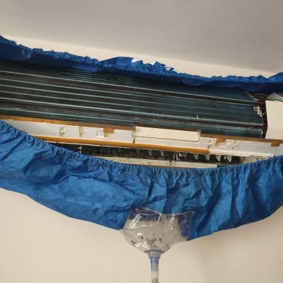 מזגן מפורק עם כיסוי כחול לניקוי