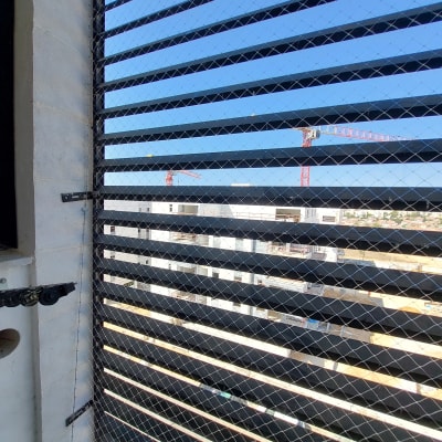 רשת מתכת מותקנת על חלון למניעת כניסת יונים