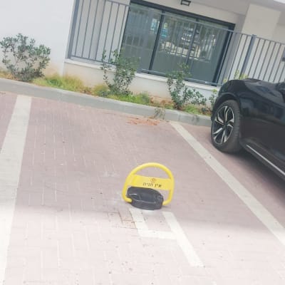 מחסום חניה צהוב בחניון ליד בניין מגורים