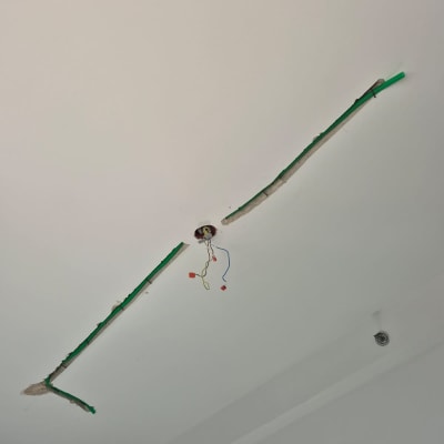 חוטי חשמל יוצאים מהתקרה עם צינור ירוק