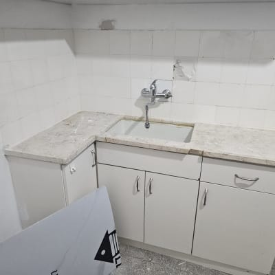 כיור מטבח עם ברז, ארונות ותיקון קיר