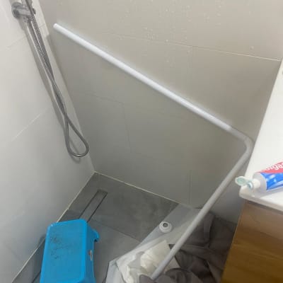 מקלחת עם שרפרף כחול ומוט לבן