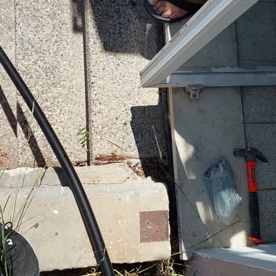 פטיש ושקית אזיקונים על מדרגה ליד צינור שחור