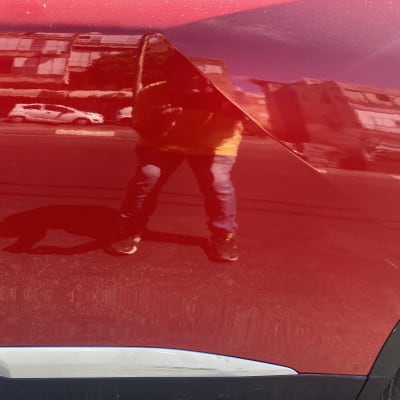 צבע אדום מבריק על דלת רכב עם השתקפות