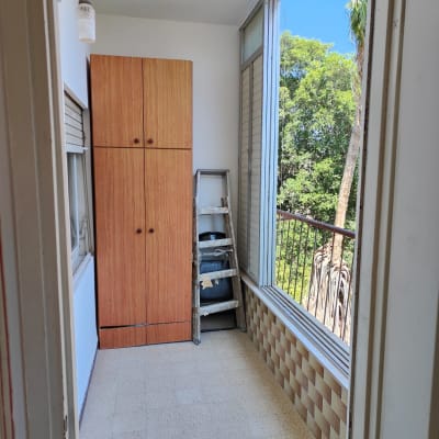 סולם עץ עם כתמי צבע ליד ארון עץ