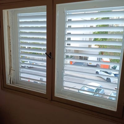 חלון עם תריסים פתוחים חלקית