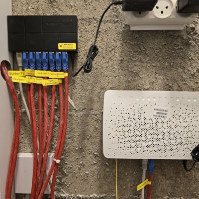 נתבים וכבלים מחוברים לקיר עם תוויות זיהוי