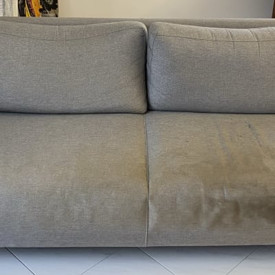 ספה אפורה עם כתמים על המושב