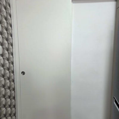 דלת הזזה לבנה על קיר עם טפט גיאומטרי