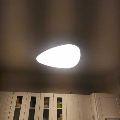 תאורה מותקנת בתקרה מעל ארונות מטבח לבנים