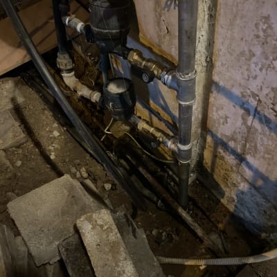 צינורות מים וברזים מותקנים על קיר בטון