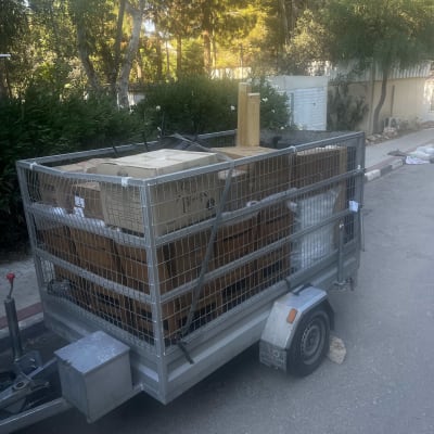 נגרר מועמס בארגזי קרטון ורהיטים המיועדים להובלה