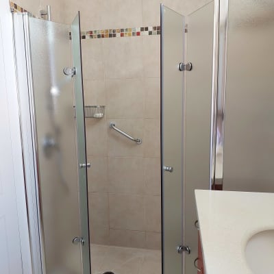 מקלחת עם דלתות זכוכית וידית אחיזה