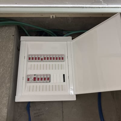 לוח חשמל פתוח עם מפסקים וחוטים ירוקים וכחולים