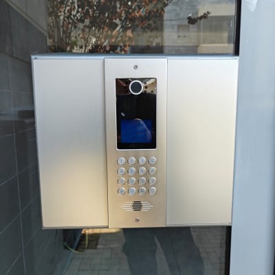 אינטרקום עם מצלמה ומקשים על קיר זכוכית