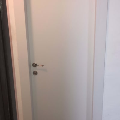 דלת לבנה עם ידית מתכת כסופה