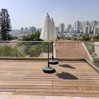 מרפסת עץ עם שמשיות לבנות על בסיסים כבדים