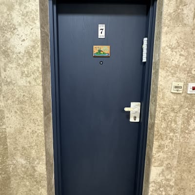 דלת כחולה עם שלט מספר 7 על קיר אבן