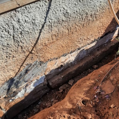 קיר בטון עם איטום חלקי וסדקים גלויים