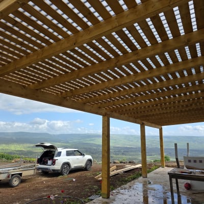 פרגולה מעץ עם נוף הררי ורכב חונה