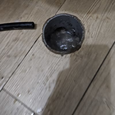 צינור ביוב פתוח עם מים על הרצפה