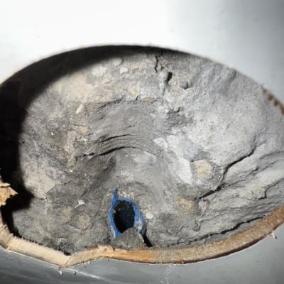 חור בקיר עם צינור כחול חשוף