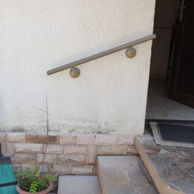 מעקה מתכת על קיר לבן ליד מדרגות